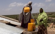 Women collect water in jerry cans.