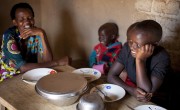 Violette Bukeyeneza sitting at her new kitchen table with her children, Amida Tuyishimire, Rashid Niyogushimwa, Lievain Irankunda, Idrissa Nzoyisaba 8, and Ghyslaine Iteriteka 6. Photo: Abbie Trayler-Smith / Concern Worldwide.