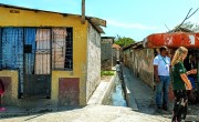 Concern staff member speaking to people against brightly coloured houses in shanty town