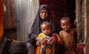 Rugiyo*, a woman in a black niqab, holds her two infant sons 