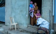 Maram and two of her children in the doorway of the building they live in