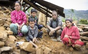 Seventy-year-old Krishna Prasad Sapkota crouches alongside his daughter-in-law, Ausara, grandsons, Prashant and Nishant, and wife, Shuvada, in the mud and stone that used to make up their home. He took out a loan to build a new home for his family and was putting the finishing touches on it when the earthquake hit on April 25, 2015. (Photo: Crystal Wells/Concern Worldwide)