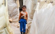 A young Syrian refugee stands between the tents at an informal settlement in the north of Lebanon. Photo: Dalia Khamissy / Concern Worldwide. 