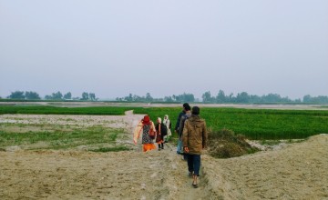 Community members from Dakhin Dawabari Char of Dawabari Union, Hatibanda, Bangladesh show the way to reach their community on the hour long walk across the sand of the dried river bed during dry season. In monsoon season, the river swells, filling all the area covered in sand in this photo, completely isolating this community. Photo: Amy Rose McGovern / Concern Worldwide