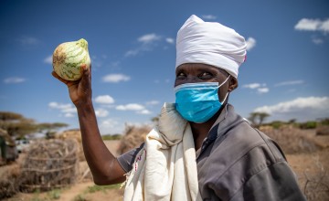 Guyo Gonjoba holds up fruit that his community in northern Kenya have been able to grow in their kitchen gardens with support from Concern.