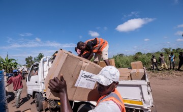 Workers unload kitchen kits from a truck at a distribution in Ndeja, Mozambique, which was hard hit by cyclone Idai in March 2019. Photo: Tommy Trenchard / Concern Worldwide.