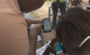 A nurse showing her patient healthcare options on a phone