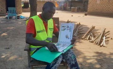 Edmond Narcisse, RECO RELSUDE, leafing through his image box for awareness raising. Photo: Concern Worldwide.