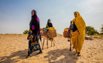 Chadian women traveling great distances to gater water in a desert.