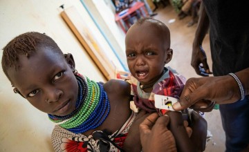 Ngirethi Ekakutan holds her younger sister, Mary, as they wait to be screened for malnutrition at Sasame Dispensary, Kibish North, Turkana, Kenya. Photo: Lisa Murray/Concern Worldwide