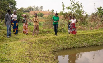 Group speaking on banks of pond