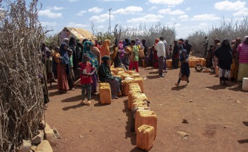 Group of people gathered around jerry cans 