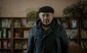 Artem* (76) inside a children’s library while he waits to be verified for a cash transfer. Photo: Simona Supino/Concern Worldwide