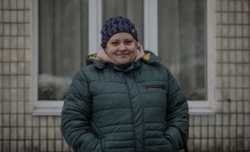 Daniela* waits outside a library to be called inside to be verified to receive a cash distribution. Photo: Simona Supino/Concern Worldwide