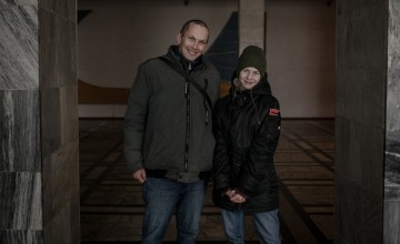 Victor* and his daughter Slava* wait inside the entrance of a library as the await verification that they can receive a cash transfer. Photo: Simona Supino/Concern Worldwide
