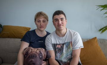 Sofia and her son Anton sit next to each other on sofa