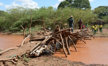 A Concern staff, Omar Bawata, attempts to cross a make shift bridge in Handaraku village, Tana River county. Photo: Shaloam Strooper/Concern Worldwide