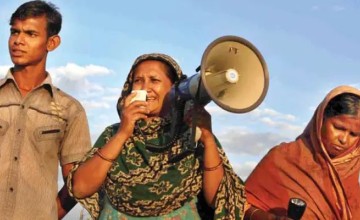 A community participating in Paribartan works with their early warning kits, including a megaphone and radio kit.