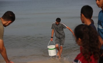 People collect sea water in southern Gaza, to use the water for cooking, cleaning and personal hygiene.