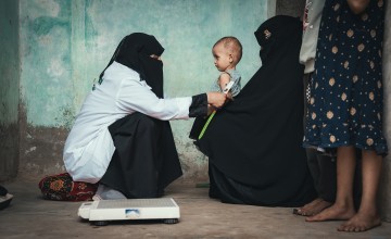Rima* with her mother and Nabilah, the Community Health Volunteer