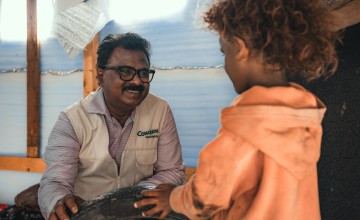 Victor Moses, Yemen Country Director, chats to a child 