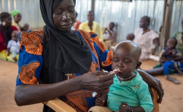 A woman from South Sudan feeds her son