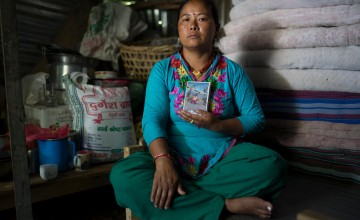 Sua Tamang holds photographs of her son who was killed when the earthquake destroyed the hotel she owned and ran with her husband in Singati, Dolakha District. Photo: Brian Sokol/Panos Pictures/Concern Worldwide