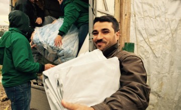 A Syrian refugee receives emergency support items from Concern Worldwide in an informal settlement of refugees in Akkar province, northern Lebanon. Photo: Amanda Ruckel / Concern Worldwide.
