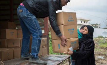 A Syrian refugee woman receives winter clothes distributed to Syrian refugees by the Concern Worldwide team at the informal tented settlement in Akkar, northern Lebanon.Photo taken by Dalia Khamissy/ Concern Worldwide.