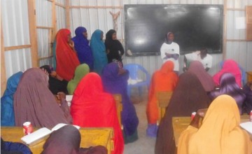 Children listen to their colleague Amal Ali Ibrahim in a Concern-run, EU-funded accelerated basic education centre in Siliga IDP camp in Wadajir district, Somalia. Photo taken by Mohamed Abdulle Farayare for Concern Worldwide.