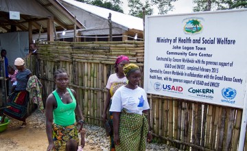 Women leaving the Community Care Center in John Logan Town, Grand Bassa County, Liberia. The center, built by Concern Worldwide, was designed to treat Ebola patients but has been transformed into a general health center. Photo taken by Kieran McConville/Concern Worldwide.