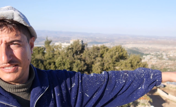 A Syrian refugee in Lebanon points to the Syrian border and his home town in the distance. Photo taken by Kieran McConville / Concern Worldwide.