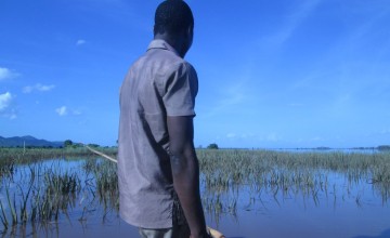 Connex Makitchansi stands at the prow of a dug-out canoe, gazing at the damage to crops at his family’s farm in Malawi. Photo taken by Fumbani Chihana, Concern Worldwide.