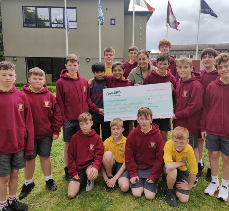 Class from Scoil Assaim BNS Raheny holding cheque for money raised for Concern