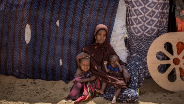 Naima* with her children outside their hut at in an IDP site in Somalia. Photo: Mustafa Saeed