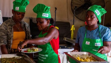 Three women in Concern chef hats cooking meal