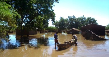 Two people with canoe in floodwater following Cyclone Freddy in Malawi