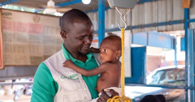 Concern's Early-Child Development Officer Mahamadou Boubakar helps healthcare staff at the Concern-supported intensive nutritional recovery centre (CRENI) at Tahoua Hospital carry out an initial assessment of 13-month-old Nana-Aicha who is severely malnourished. (Photo: Darren Vaughan/Concern Worldwide)