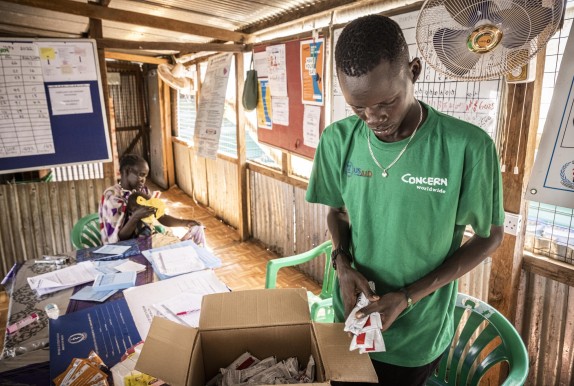 Concern health worker holding packets of RUTF 