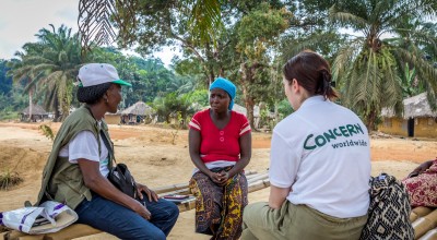 Irene Togbah from Ceayah Town talks with concern workers Nelly Smith and Marie Madden about her struggles without a clean source of water. Photo: Gavin Douglas/Concern Worldwide.