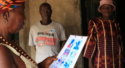 A resident of Bassaia Village looks at a COVID-19 poster. 