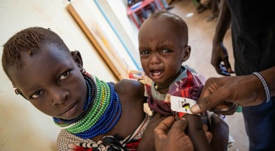 Ngirethi Ekakutan holds her younger sister, Mary, as they wait to be screened for malnutrition at Sasame Dispensary, Kibish North, Turkana, Kenya.  Photo: Lisa Murray/Concern Worldwide
