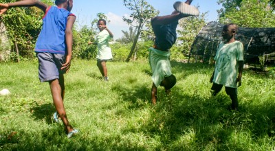 Children playing and performing handstands on the grass 