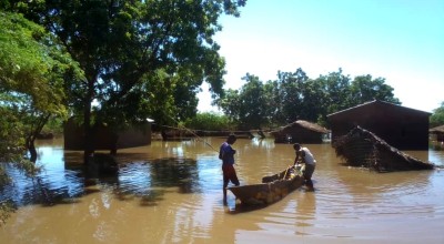 Two people with canoe in floodwater following Cyclone Freddy in Malawi