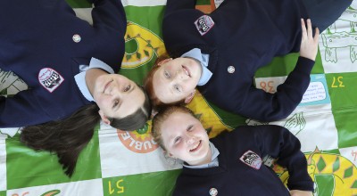 Three Concern Debates runners up lying on colourful mat and looking up at camera