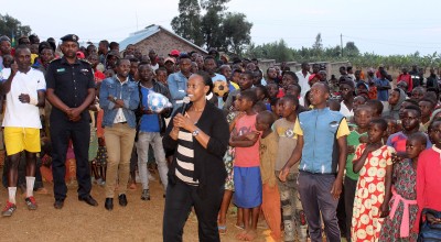 Denise Dusabe, Vice Mayor of Social Affairs in Gisagara district, presents at an HIV/AIDS prevention and family planning event organized by Concern Rwanda. Five local teams participated in a soccer championship, with government representatives presenting both speeches and prizes. Local health center staff also offered voluntary HIV testing, distributed free condoms, and helped couples with selecting appropriate family planning methods.