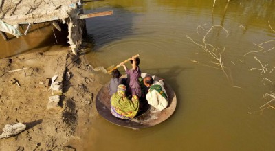 Aqib Aliin (14) transports people on his frying pan across the flooded waters in Jhuddo town of District Mirpurkhas of Sindh, Pakistan, in October 2022. The worst floods in decades impacted over 33 million people. Photo: Emmanuel Guddo/Concern Worldwide