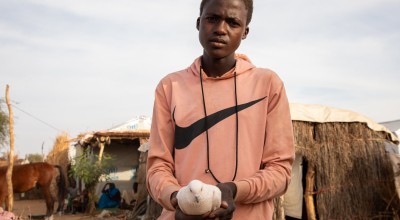Younous holds up one of his pigeons at his shelter in a refugee camp in Eastern Chad. Photo: Eugene Ikua/Concern Worldwide