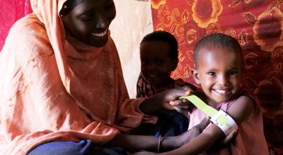Halima Bare measures her  child Iqra Hassan's mid upper arm circumference (MUAC),