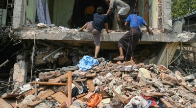 People climb into a damaged building as they look for survivors in Mandalay on March 29, 2025, a day after an earthquake struck central Myanmar. 